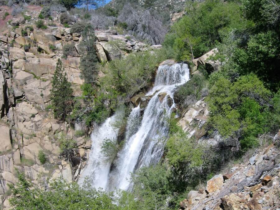 Cascading water fall of Kern River surrounded by green trees and rocky hills. Link to Kern County page.