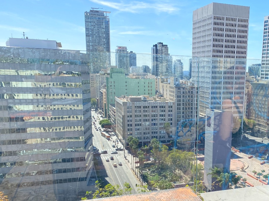 Elevated view of downtown Los Angeles buildings and street with glass plane in front. Link to Where to Eat on page.