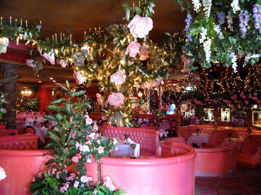 Elaborately decorated Madonna Inn restaurant with different flowers all over and pink booths. Link to Where to Eat on page.