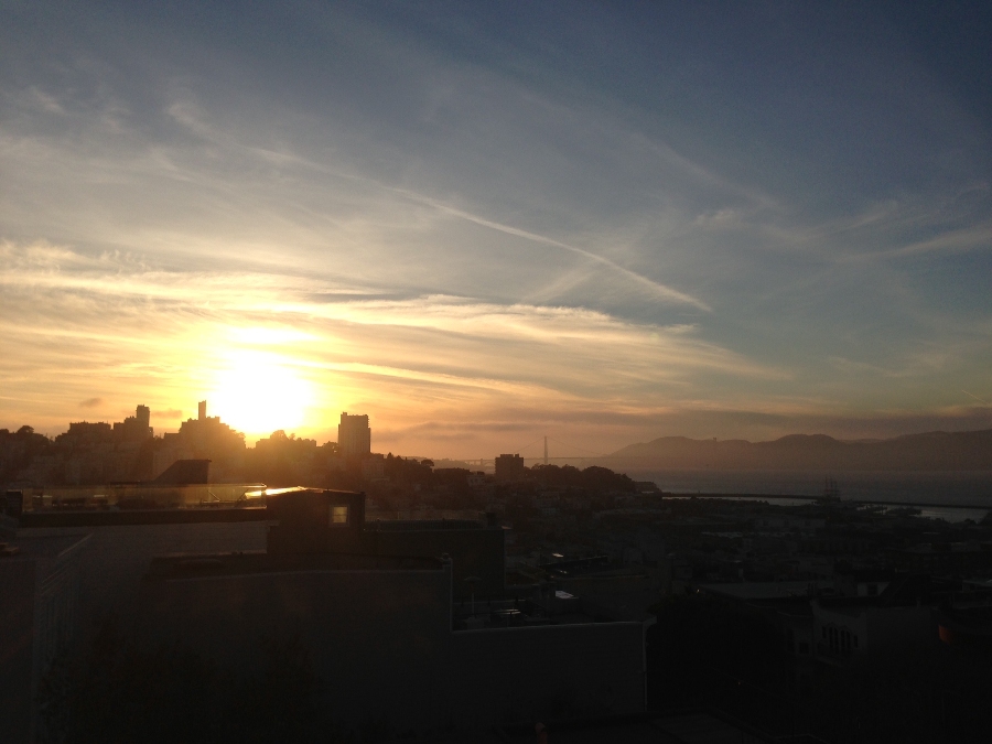 Silhouette of San Francisco building skyline with glowing yellow sunset behind. Link to San Francisco page.