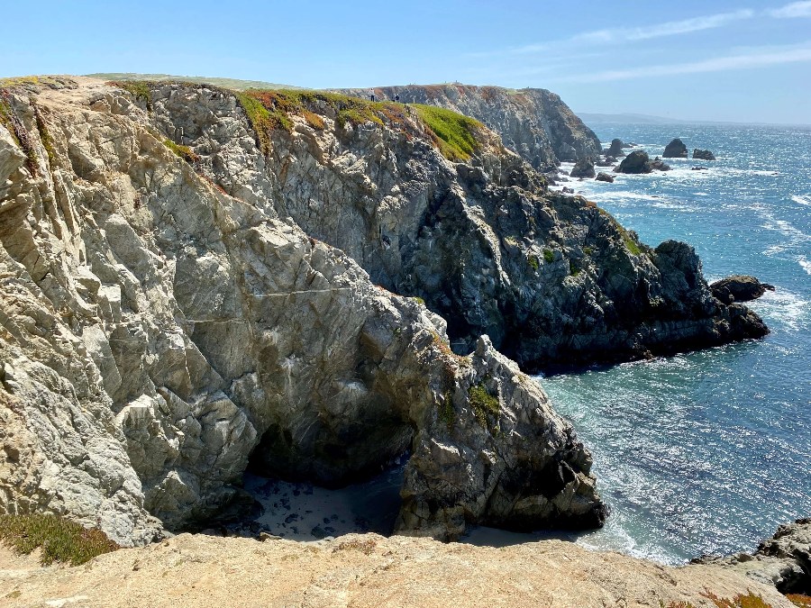 Rocky cliffside of the pacific ocean at Bodega Beach in Sonoma County. Clear blue sky.